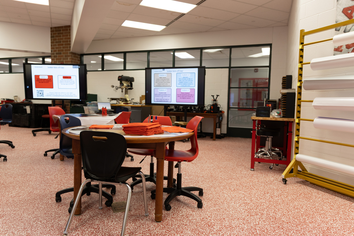Multiple screens, table and chairs, and other equipment in the Madison LSD Innovation Lab.